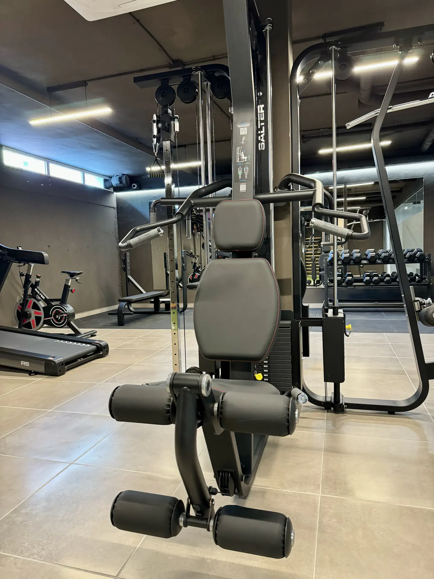 Zona de musculación del gimnasio con equipamiento diverso