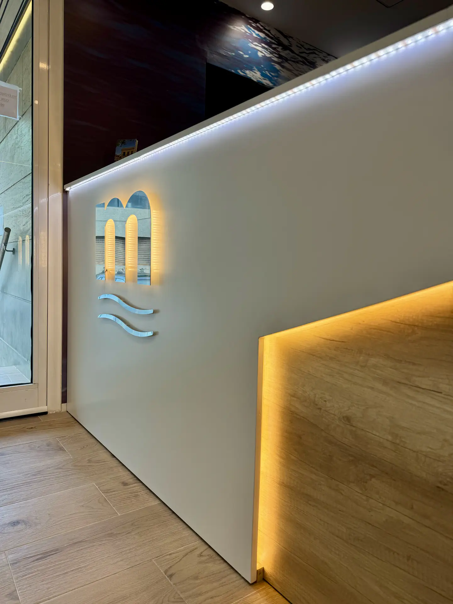 Zona de recepción con iluminación cálida y zona de estar